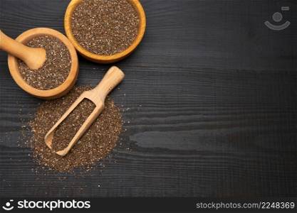 Organic natural chia seeds, bowl and wooden scoop close-up on wooden background or table. High quality photo. Organic natural chia seeds, bowl and wooden scoop close-up on wooden background or table