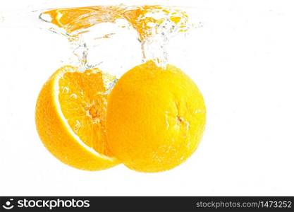 Organic orange sliced in half sinking into crystal clear water with air bubbles. Isolated on a white background. Product label concept. Organic orange sliced in half sinking into crystal clear water with air bubbles