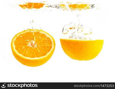 Organic orange sliced in half sinking into crystal clear water with air bubbles. Isolated on a white background. Product label concept. Organic orange sliced in half sinking into crystal clear water with air bubbles
