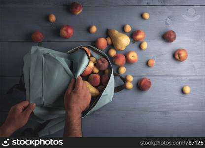 Organic peaches and apricots on a blue table. Fresh harvested fruits, apples, pears and peaches