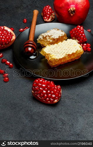 Organic Pomegranate and honeycomb close-up macro studio shot. Pomegranate and honeycomb close-up on dark concrete background