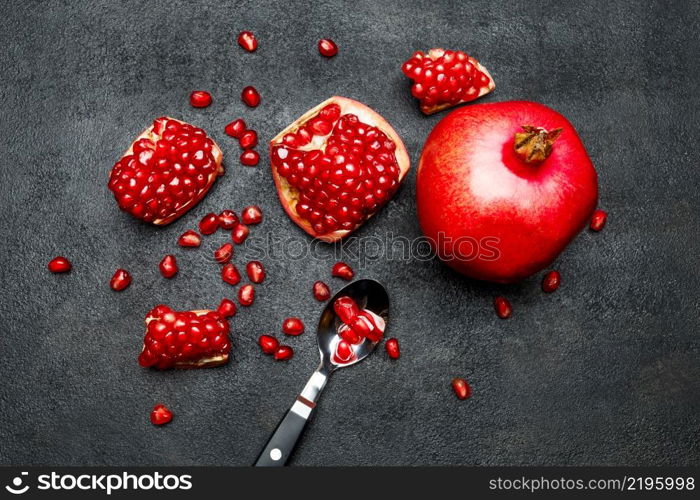 Organic Pomegranate and seeds close-up macro studio shot. Pomegranate and seeds close-up on dark concrete background