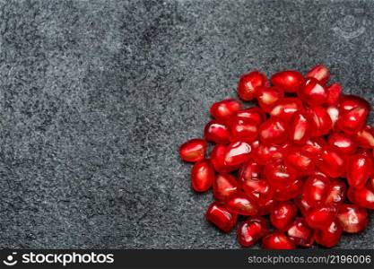 Organic Pomegranate seeds close-up macro studio shot. Pomegranate seeds close-up on dark concrete background