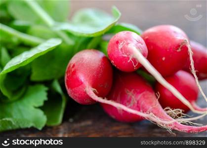 Organic radishes on the wooden board in the kitchen.