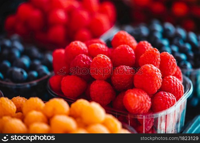 Organic raspberries and blueberries on a farmers market