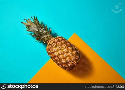 Organic ripe pineapple on a blue orange background with copy space for text, top view. Tropical Pineapple fruit on a blue orange background