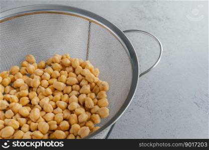 Organic seeds in sieve. Dry chickpeas for healthy eating. Overhead view. Nutrient dense food. Garbanzo beans containig lot of protein
