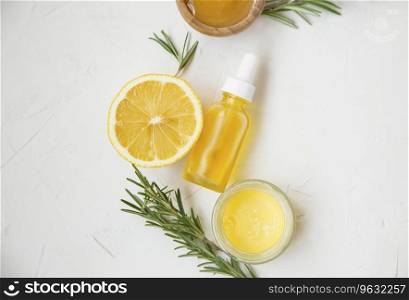 Organic skincare ingredients with lemon and rosemary oil bottle and herb, manuka honey and balm salve, top view on white background