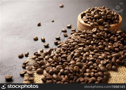 Organic toasted coffee beans on rustic black stone table with copy space for your text