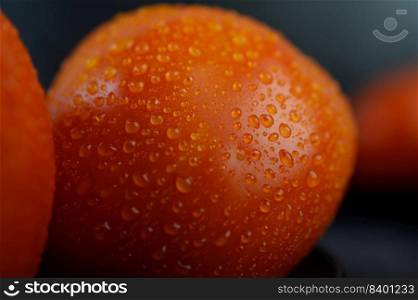 Organic tomato with water droplets in closeup macro.