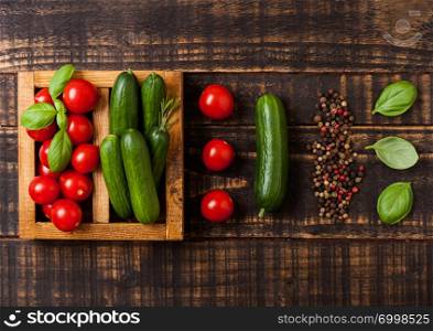 Organic Tomatoes and cucumber with basil and linen towel in vintage wooden box on wooden table
