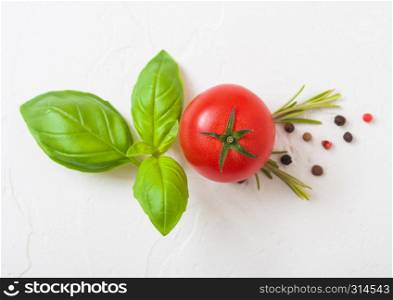 Organic Tomatoes on the Vine with basil and pepper on white kitchen stone background