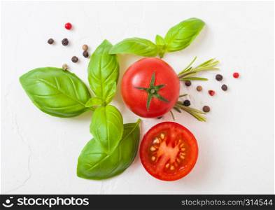 Organic Tomatoes on the Vine with basil and pepper on white kitchen stone background
