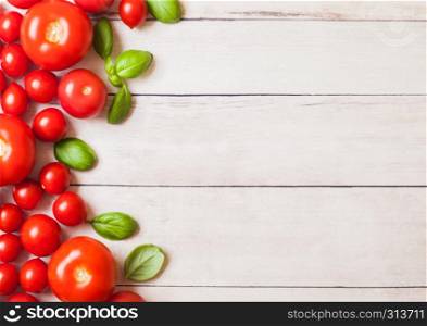 Organic Tomatoes on the Vine with basil on white kitchen woden background