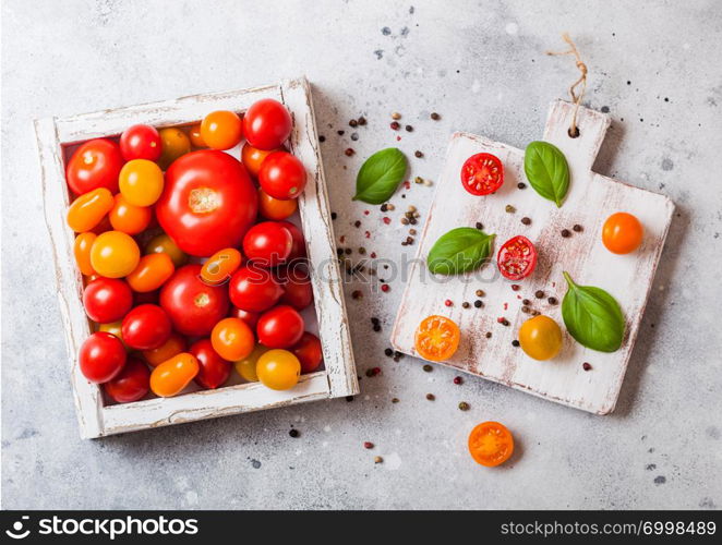 Organic Tomatoes with basil in vintage wooden box on stone kitchen table