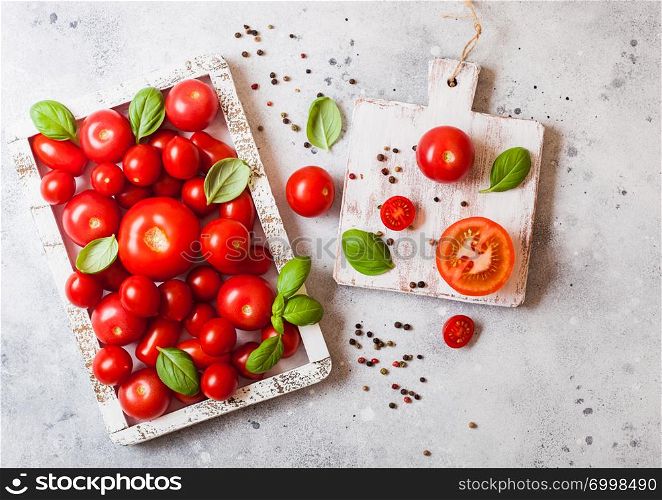 Organic Tomatoes with basil in vintage wooden box on stone kitchen table