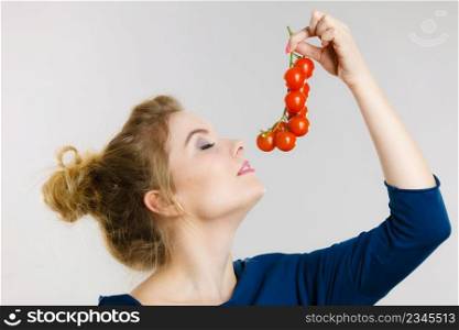 Organic vegetables and food concept. Happy positive smiling woman holding fresh cherry tomatoes. Woman holding fresh cherry tomatoes