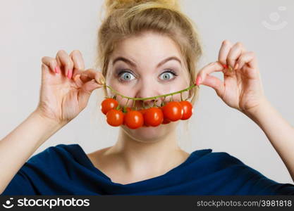 Organic vegetables and food concept. Happy positive smiling woman holding fresh cherry tomatoes. Woman holding fresh cherry tomatoes