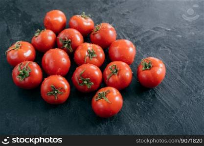 Organic vegetables and healthy eating concept. Harvested red tomatoes with water drops, black background. Close up texture. Open air market