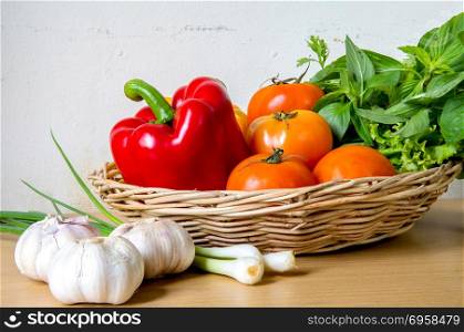 Organic vegetables in the wicker basket on wooden background