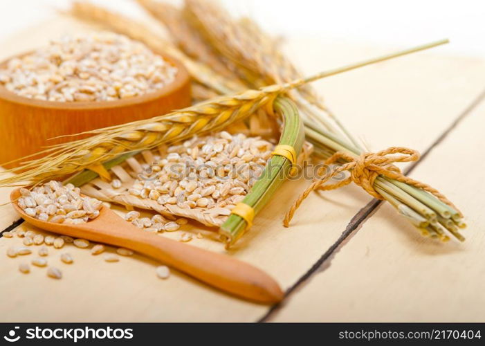 organic wheat grains over rustic wood table macro closeup