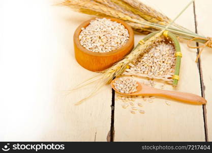 organic wheat grains over rustic wood table macro closeup