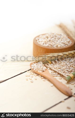 organic wheat grains over rustic wood table macro closeup