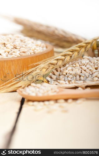 organic wheat grains over rustic wood table macro closeup