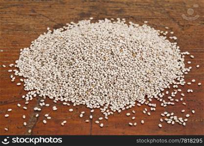 organic white chia seeds rich in omega-3 fatty acids - superfood - on a grunge wood surface