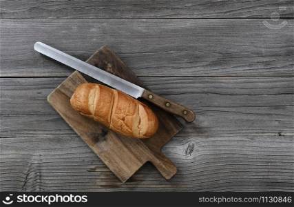 Organic whole wheat loaf with large curated knife on cutting board in top view layout