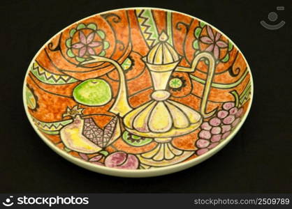 oriental antique ceramic plate on a black background closeup. oriental antique ceramic plate