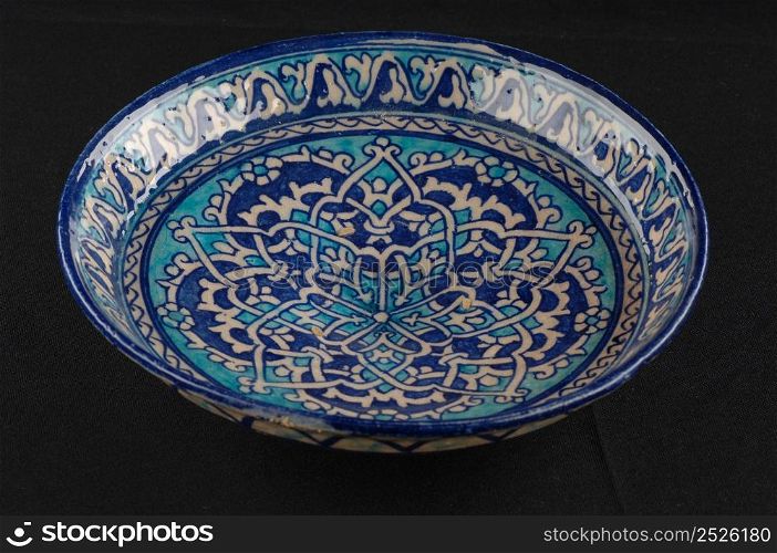 oriental antique ceramic plate on a black background closeup. oriental antique ceramic plate