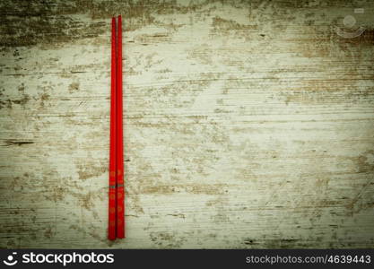 Oriental chopsticks in red on a wooden background