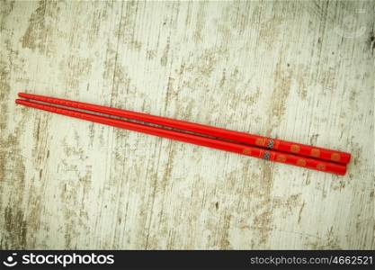 Oriental chopsticks in red on a wooden background