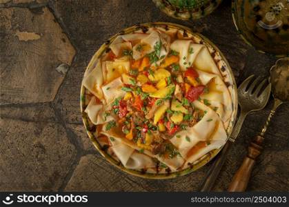oriental dishes on decorative old tiles. dish dough. meat dish on an old paving stone