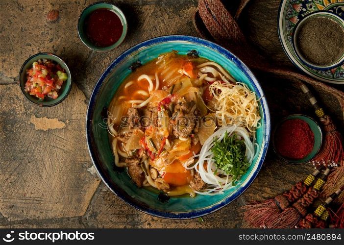 oriental dishes on decorative old tiles. noodles and spices with braid on decorative old paving stones. meat dish on an old paving stone