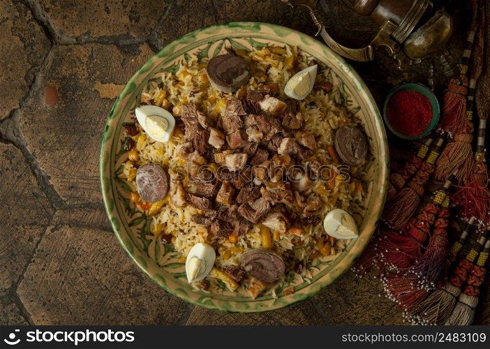 oriental dishes on decorative old tiles. pilaf and pitcher on decorative old paving stones. meat dish on an old paving stone