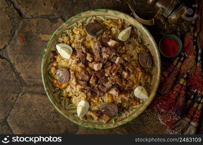 oriental dishes on decorative old tiles. pilaf and pitcher on decorative old paving stones. meat dish on an old paving stone