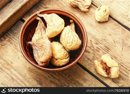 Oriental dried figs in bowl on wooden vintage background. Delicious dried figs