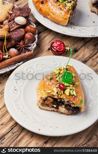 oriental fruit cake. piece of cake with dates, fruits and nuts on a saucer