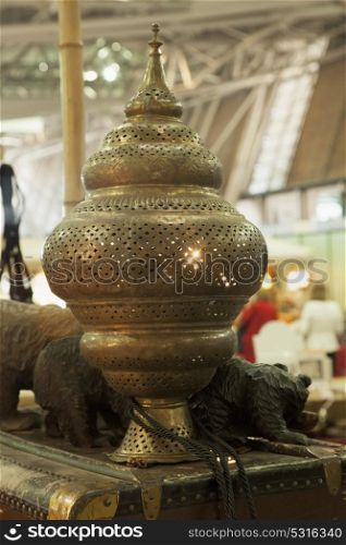 Oriental golden lamp over wooden cask, vertical image