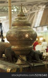 Oriental golden lamp over wooden cask, vertical image