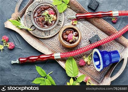 Oriental hookah with tobacco with the aroma of raspberry jam.Eastern shisha. Turkish hookah with raspberries