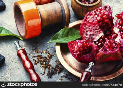 Oriental smoking hookah.Pomegranate flavor hookah.Fruit tobacco shisha. Arabian shisha with pomegranate