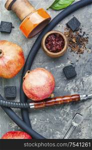 Oriental smoking hookah.Pomegranate flavor hookah.Fruit tobacco shisha. Modern hookah with fruit