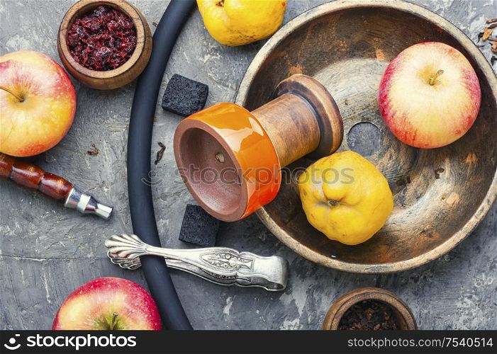 Oriental smoking shisha.Hookah bowl and tobacco.Details of Turkish nargile.Kalian tobacco with apple aroma and quince.. Egyptian hookah on apple