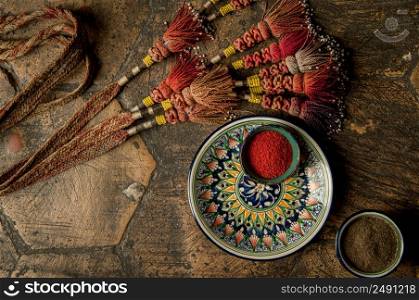 oriental spices in cups and decorated adorned with a whip on an old worn paving stone. oriental spices and decorations on decorative old tiles. oriental spices on an old paving stone