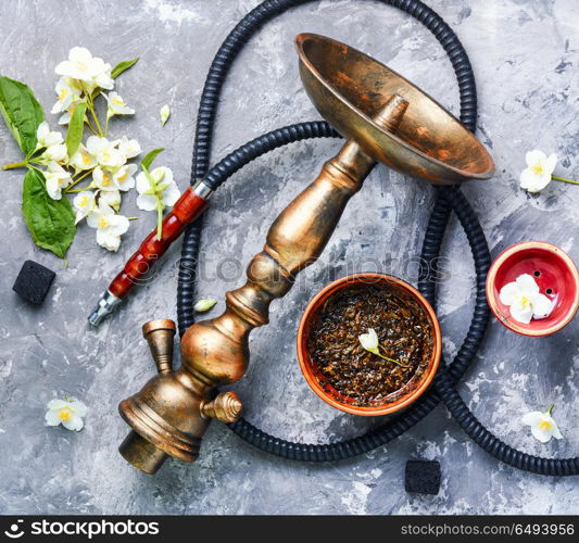 Oriental tobacco hookah with floral jasmine aroma. Smoke hookah with jasmine floral scent.Shisha concept.Modern hookah