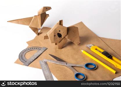 origami dinosaur and koala made of paper. paper, ruler, pencils, knife. interesting hobby