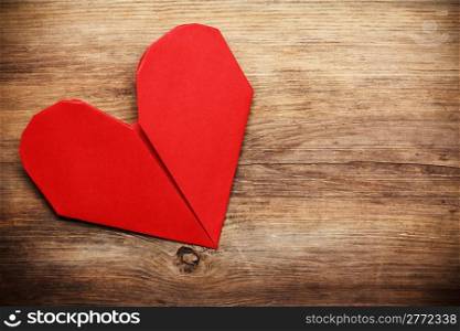 Origami heart on wooden background with copy-space